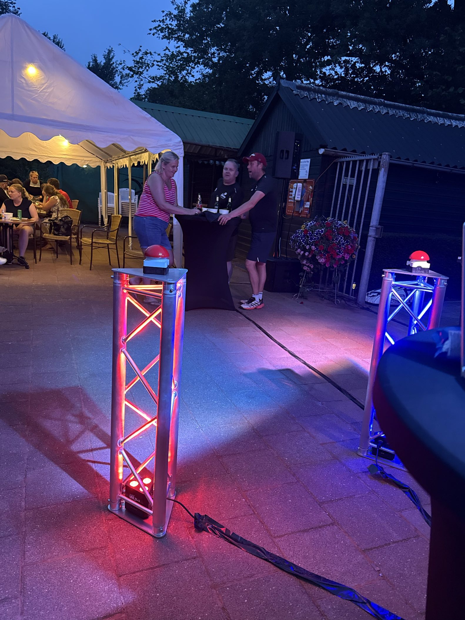 Verlichte buzzer-zuilen tijdens een Battle Quiz op een tennisclub in de avond